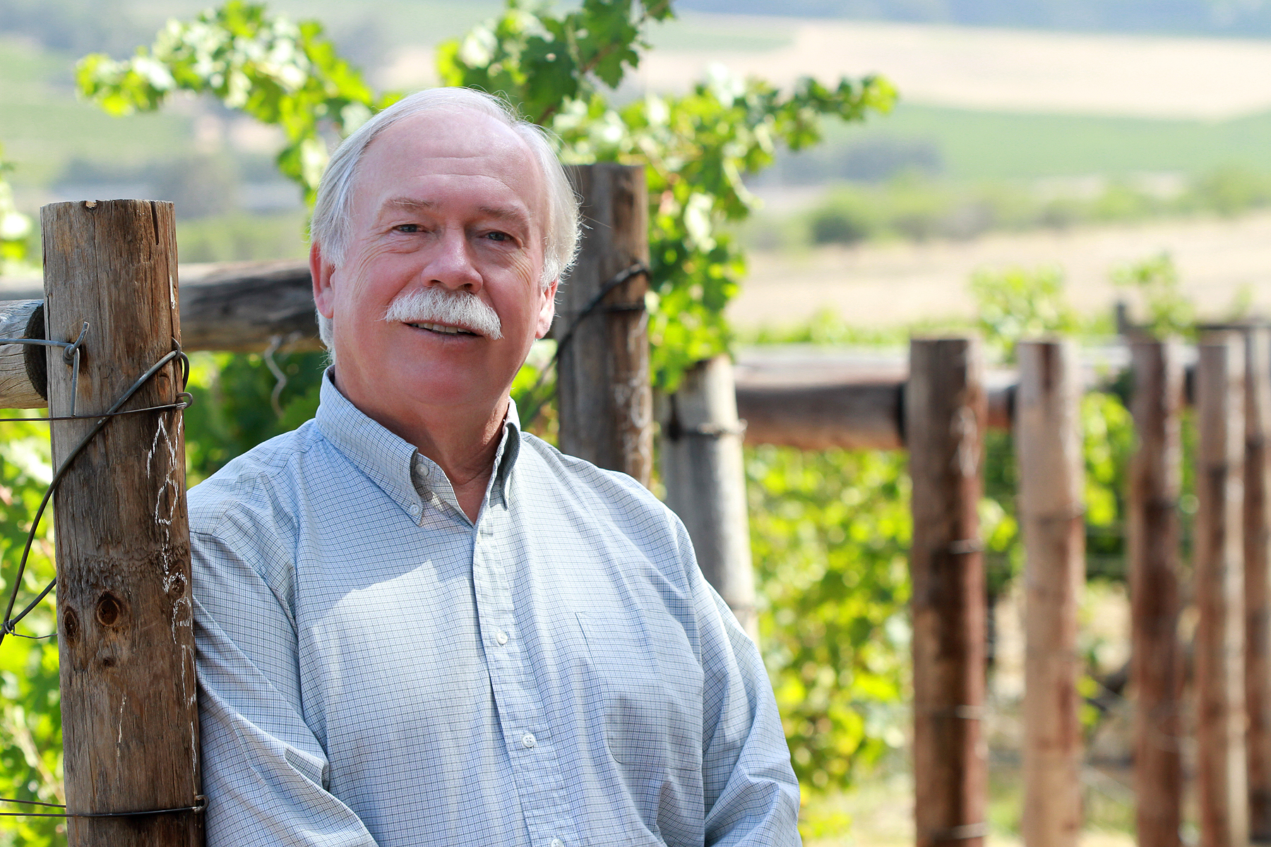 Phil Freese standing next to a vineyard